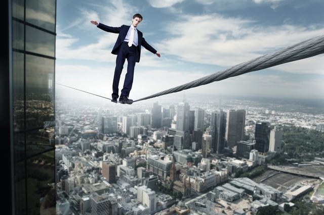Business man balancing on the rope high in the sky.jpeg