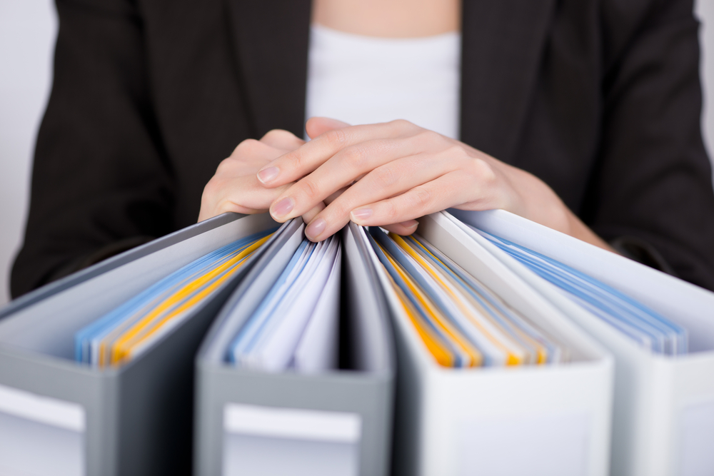 Midsection of businesswoman with binders at office-1